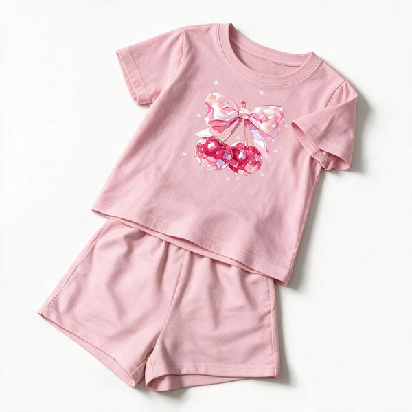 JOWI Cherry Bow Tee & Short Set photographed flat on white: the light pink short sleeve tee with the bow and cherry graphic on the chest and plain sleeves, and the matching shorts below it