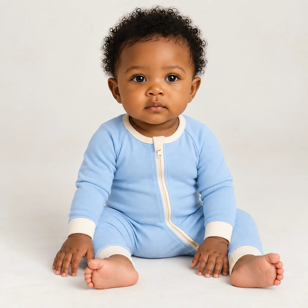 A baby wearing the JOWI Cloud Blue Baby Romper on a plain studio background, full body
