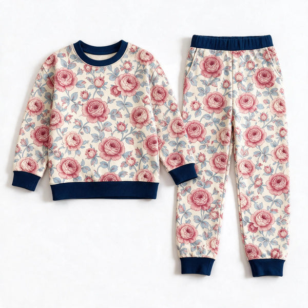 JOWI Rose Garden Pajama Set shown flat from the front, dense cherry and dusty pink roses on cream, navy ribbing