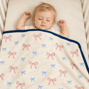 A baby wearing the JOWI Baby Blanket on a plain studio background, full body