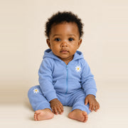 Baby girl sitting in the JOWI Blue Daisy Hoodie & Jogger Set, size 6-12 months