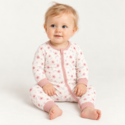 A baby wearing the JOWI Blush Floral Romper on a plain studio background, full body