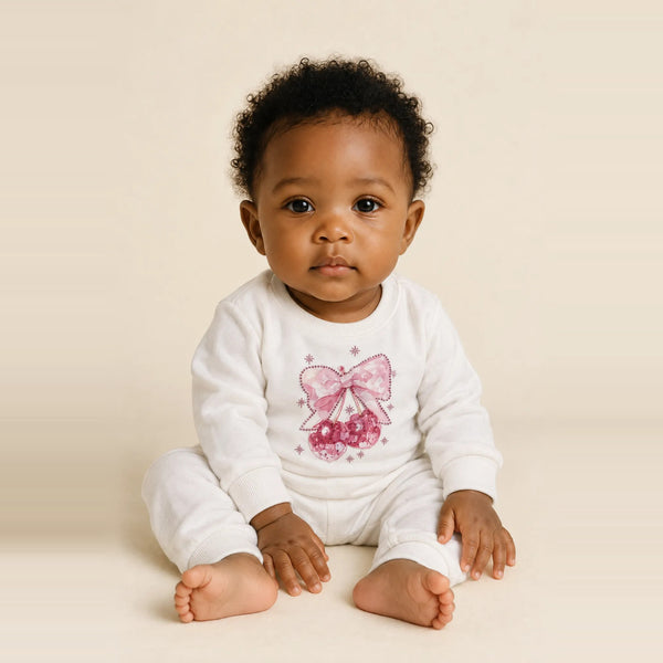 Baby girl sitting in the JOWI Cherry Bow Sweatshirt & Jogger Set, size 6-12 months