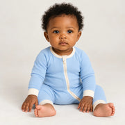 A baby wearing the JOWI Cloud Blue Baby Romper on a plain studio background, full body