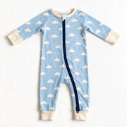 JOWI Cozy Cloud Sleepsuit shown flat from the front, cream clouds on light blue, cream trims, navy zip