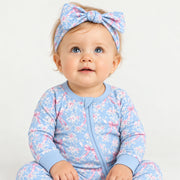 Baby wearing the bow headband with the matching blue rose toile zip romper