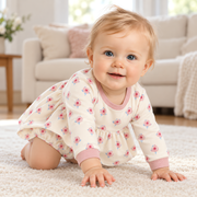 A baby moving and playing in the JOWI Little Rose Dress Set in daylight at home