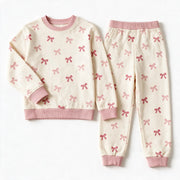 JOWI Pink Bow Baby Set shown flat from the front, small pink bows on cream, dusty pink ribbing