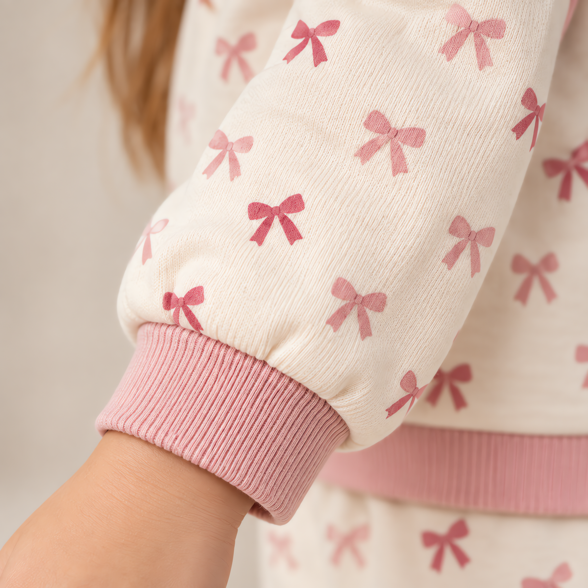 Close up of the JOWI Pink Bow Baby Set worn, with the printed cloth at true scale