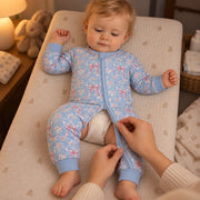 Parent unzipping the romper from the bottom for a night time nappy change, the baby's chest still covered